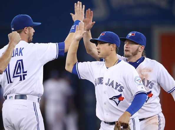 TORONTO, CANADA - AUGUST 23: Darwin Barney #18 of the Toronto Blue Jays celebrates their victory with Justin Smoak #18 and Josh Donaldson #20 during MLB game action against the Los Angeles Angels of Anaheim on August 23, 2016 at Rogers Centre in Toronto, Ontario, Canada. (Photo by Tom Szczerbowski/Getty Images) *** Local Caption *** Darwin Barney;Justin Smoak;Josh Donaldson