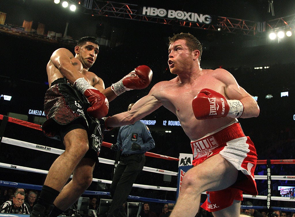 Saul Canelo Alvarez (R) of Mexico connects to the body against Amir Khan (L) of Great Britain during their WBC Middleweight Championship fight at the T-Mobile Arena, Saturday, May 7, 2016 in Las Vegas, Nevada. Saul "Canelo" Alvarez successfully defended his World Boxing Council middleweight title in spectacular fashion with a devastating sixth-round knockout of Amir Khan in Las Vegas. The 25-year-old Mexican dropped Khan with a straight right hand over a left jab that sent the Briton crumbling to the canvas with just 23 seconds left in the round. / AFP / John Gurzinski (Photo credit should read JOHN GURZINSKI/AFP/Getty Images)